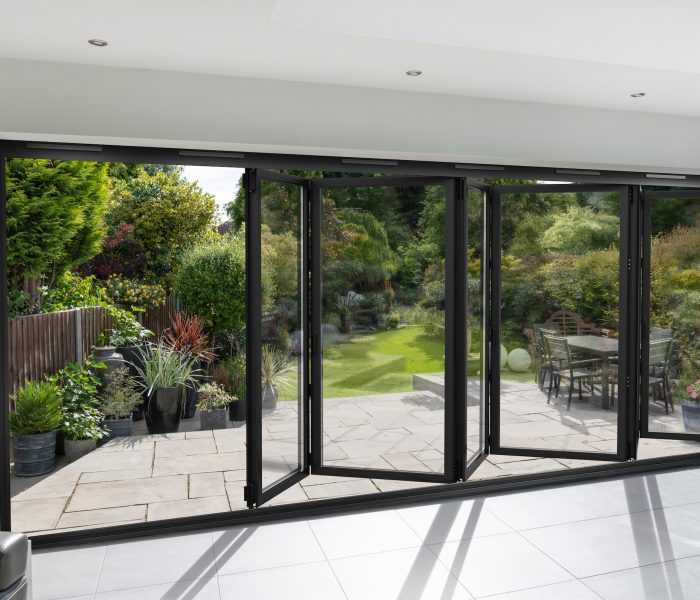 Viofold 1000 Slim bifold door in a partially open position with patio views