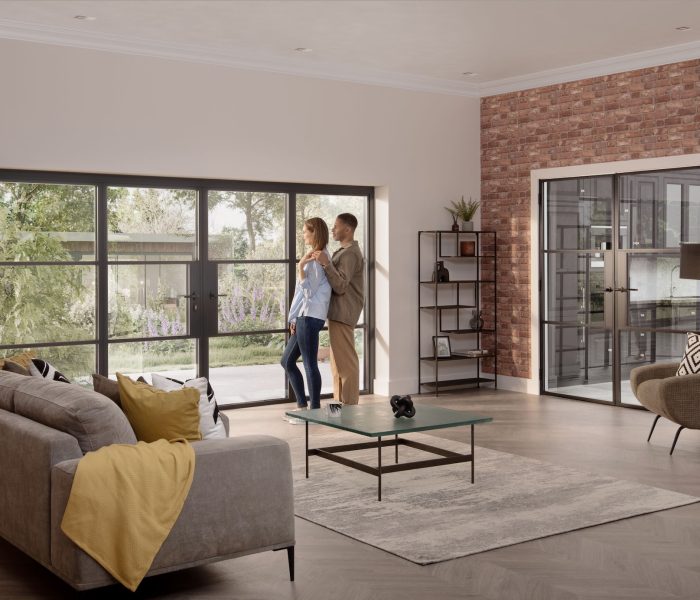 Origin OB-36+ Soho bifold in a contemporary home with a couple stood by the doors lookint to the garden